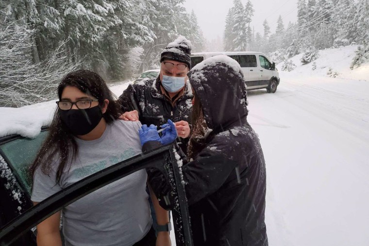 Josephine County Public Health staff and volunteers vaccinate a stranded motorist on the roadside in Oregon on Jan. 26, 2021.