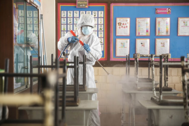Image: Members of the Bangkok Metropolitan Authority wear PPE as they sanitize classrooms in the San Chao Elementary School