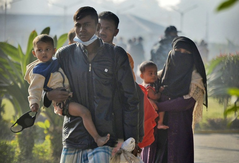 Image: Refugees carry children and walk with their belongings to be relocated to the island of Bhasan Char 