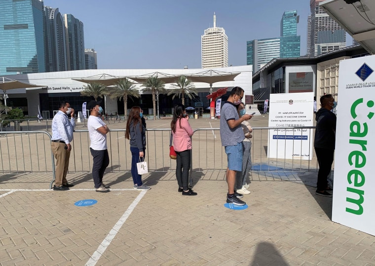 Image: People line up at a designated Covid-19 vaccination center at Dubai's financial center district