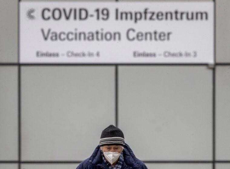Image: A man wears a face mask as he comes back from the vaccination center in Frankfurt, Germany,