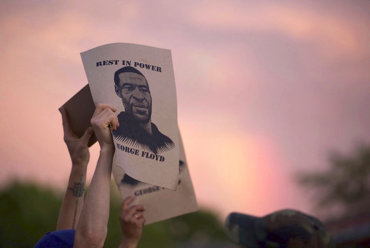 A protester holds a sign with an image of George Floyd during protests on May 27, 2020, in Minneapolis.