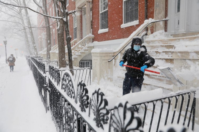 Image: A person shovels snow in the Greenwich Village neighborhood in New York