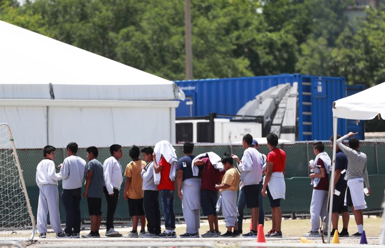 Migrant children line up outside a tent at the Homestead Temporary Shelter for Unaccompanied Children on April 19, 2019, in Homestead, Fla.
