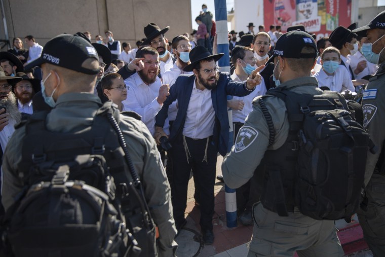 Image: Ultra-Orthodox Jews confront an Israeli officer over lockdown restrictions 