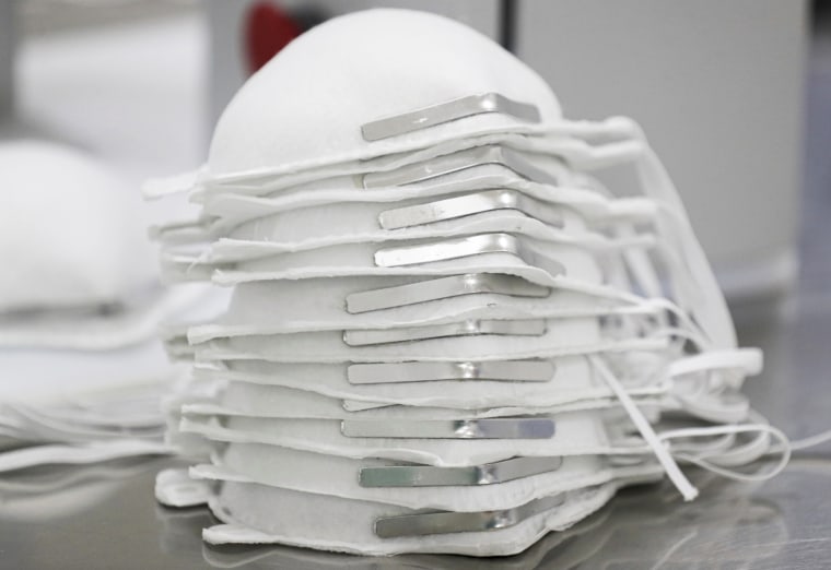 Face masks are stacked before getting technical information printed on them at a factory in Mexico City on May 21, 2020.