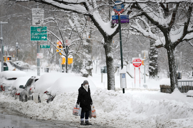 Image: Woman waits at bus stop in Manhattan after a winter storm in New York