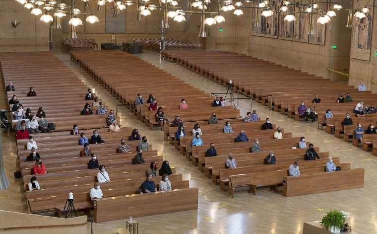 One hundred faithful sit while minding social distancing, listening to Los Angeles Archbishop Jose H. Gomez celebrate Mass at Cathedral of Our Lady of the Angels in Los Angeles.
