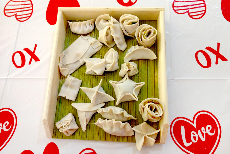 Various folds of dumplings on a tray