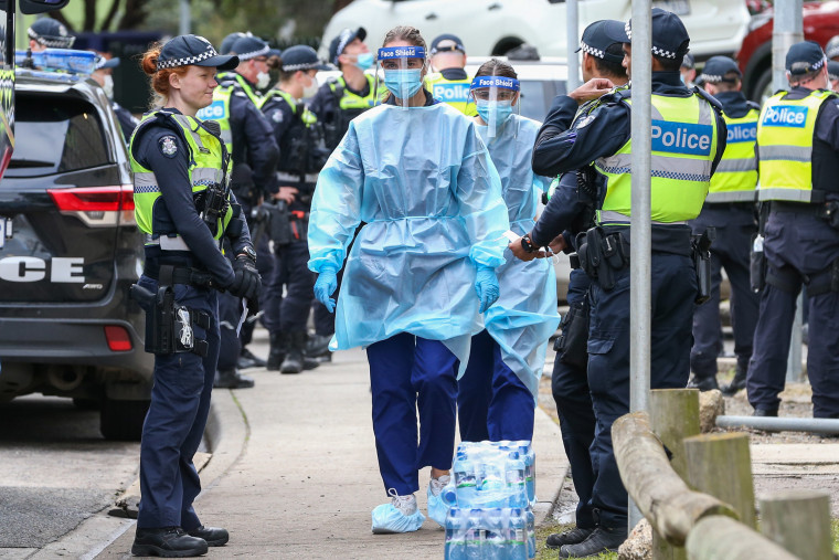 Image: Medical staff wearing PPE holding material about to walk into the Flemington Public housing flats on July 5, 2020 in Melbourne, Australia.