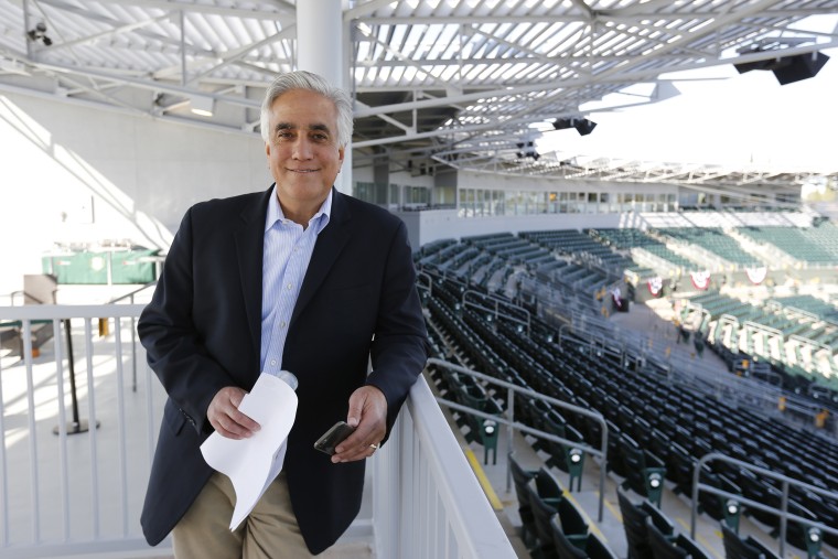 Image: Pedro Gomez of ESPN stands in the stands prior to the game between the Oakland Athletics and the San Francisco Giants at Hohokam Stadium.