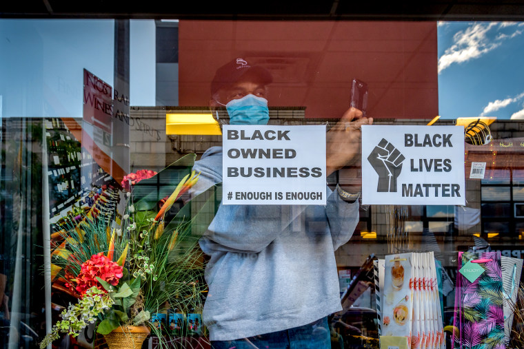 Open storefront displaying a Black Owned Business sign.