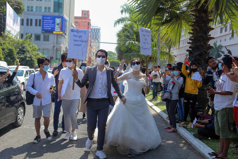Image: Protesters wearing wedding attire "Our wedding can wait but not this movement!" take part in a demonstration against the military coup in Yangon 
