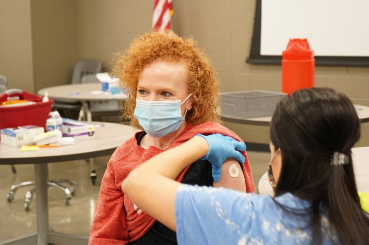 Pharmacist Megan Wilson administers the Covid-19 vaccine to Coach Emily Grimmett in Sheridan, Ark., earlier this year. McCoy-Tygart Drug, a community pharmacy, held a vaccine clinic to help inoculate teachers in the local school district.