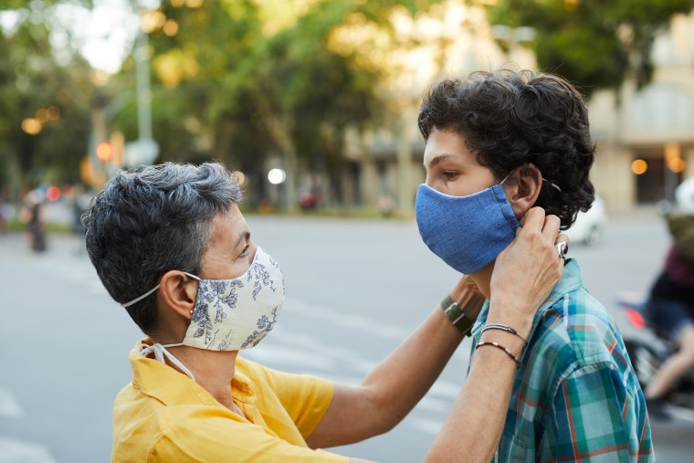 A caring mother is adjusting her teenager son's COVID mask, Shop the best masks to wear for comfort and breathability, according to doctors. Healthcare professionals share their favorite face masks to wear while off-duty.