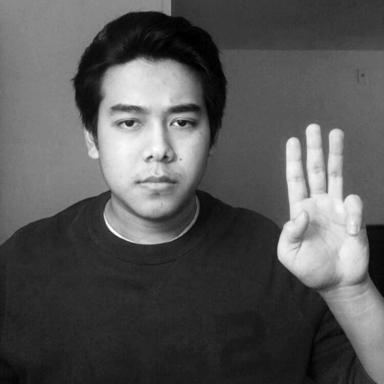 Image: Juna Ko Ko, 22, demonstrates the three-finger salute