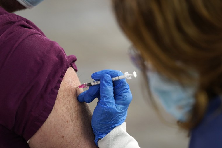 A healthcare worker receives a second Pfizer-BioNTech COVID-19 vaccine shot at Beaumont Health in Southfield, Mich., on Jan. 5, 2021.