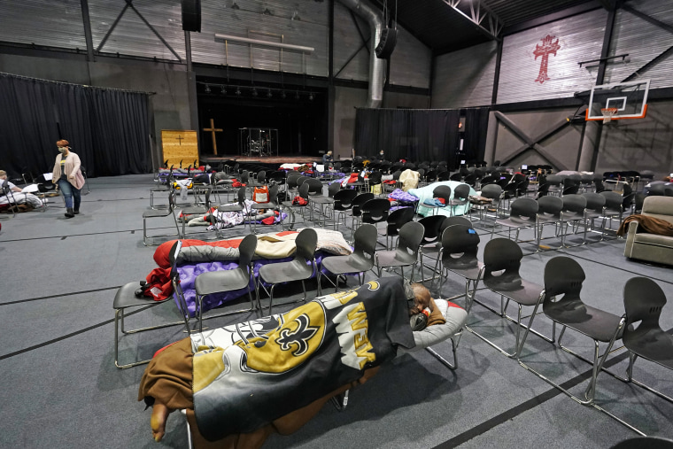 Image: People seeking shelter from below freezing temperatures rest inside a church warming center