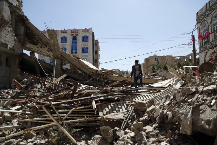 Image: A Yemeni man inspects a house that was destroyed in an airstrike carried out during the war by the Saudi-led coalition's warplanes,