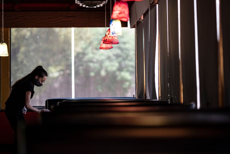 Image: Waitress disinfects a table in a restaurant in Oklahoma