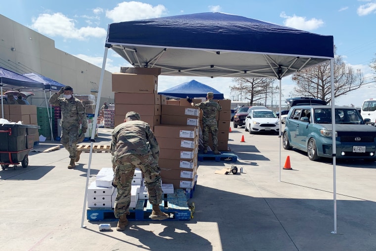 Texas National Guard members help load cars at the San Antonio Food Bank's afternoon distribution on Feb. 23, 2021.
