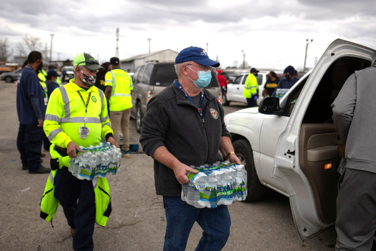 Image: Volunteers deliver water to local residents in vehicles at Butler Stadium after an unprecedented winter storm in Houston