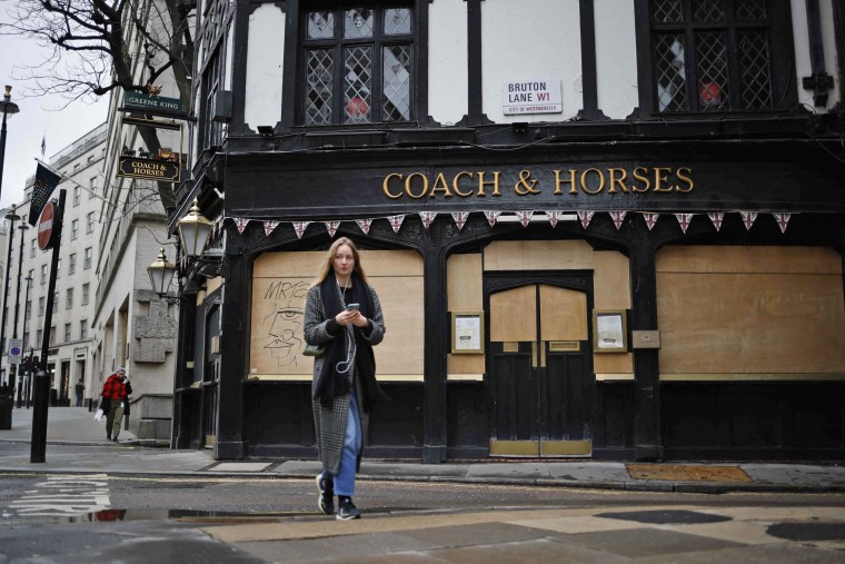 IMAGE: A pedestrian passes a boarded up pub in the Mayfair area of central London last week.