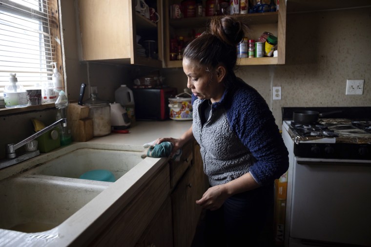 Image: Maria Pineda cleans the kitchen of a home, where she temporarily stays, on Feb. 18, 2021, in Conroe, Texas.
