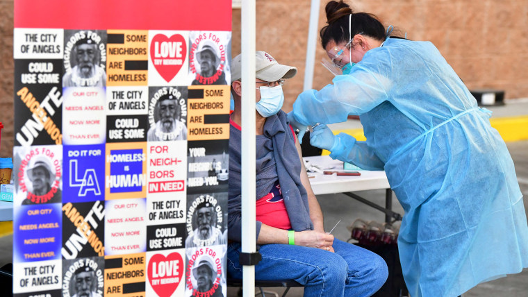 Image: Registered nurse Rhonda Ahn administers the Moderna Covid-19 vaccine to eligible people identified by homeless service agencies from the parking lot of the L.A. Mission