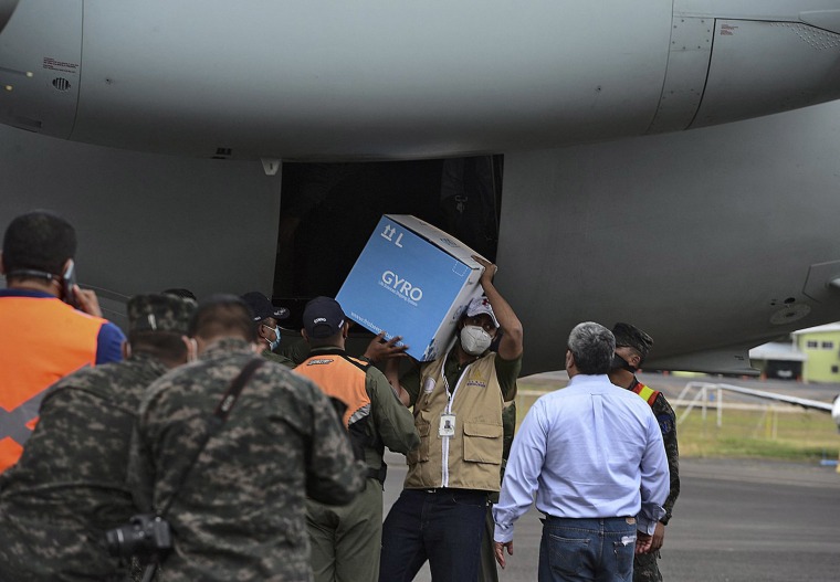 Image: A Honduran Air Force pilot unloads a box from the presidential plane as 5,000 doses of the Moderna Covid-19 vaccine donated by Israel arrive at the Hernan Acosta Mejia air base, in Tegucigalpa