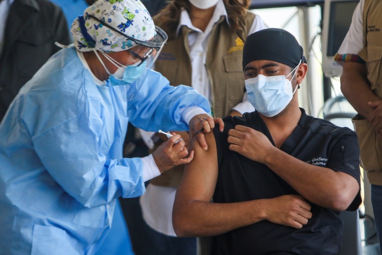 Image: Health worker Nolvin Guifarro receives a dose of the Moderna Covid-19 vaccine at the Hospital Maria, in Tegucigalpa, Honduras