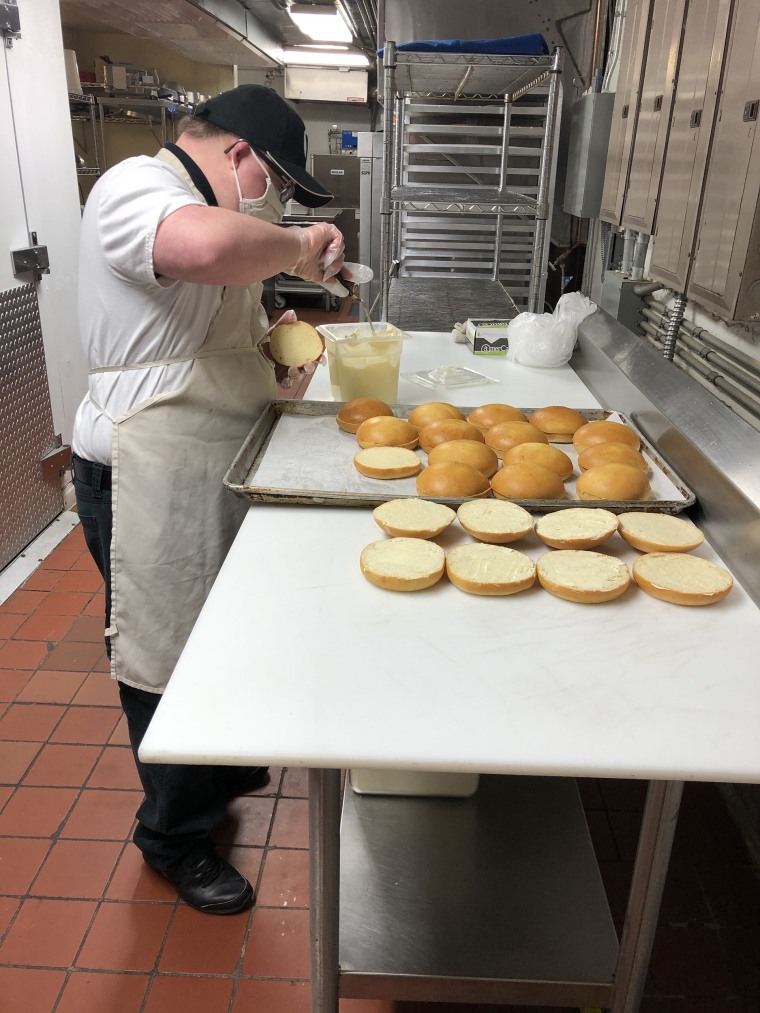 In addition to interacting with customers, Derek also gets to prepare food before it's served.