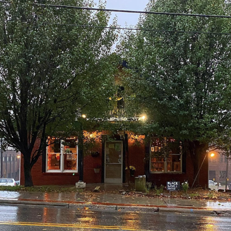 A small bookstore glows warmly as rain falls outside