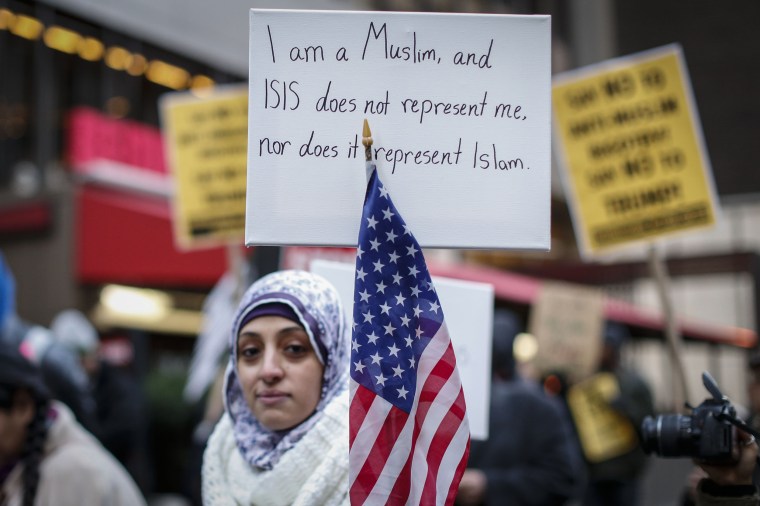 A Muslim woman holds a poster during a protest