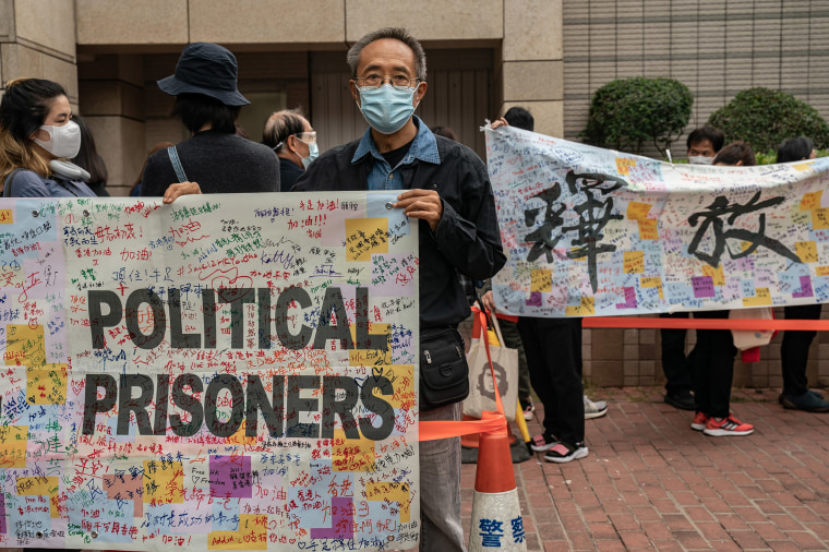 Image: Pro-democracy activists line up outside the West Kowloon court as they hold a banner reads "Release all political prisoners on March 1, 2021 in Hong Kong, China