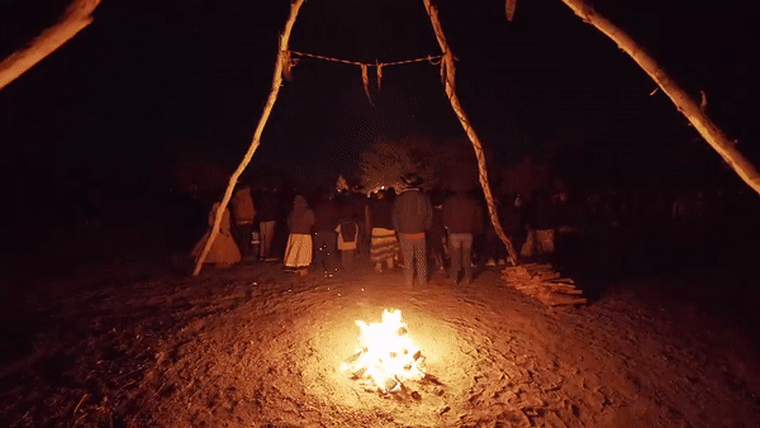 Image: People dance around a fire