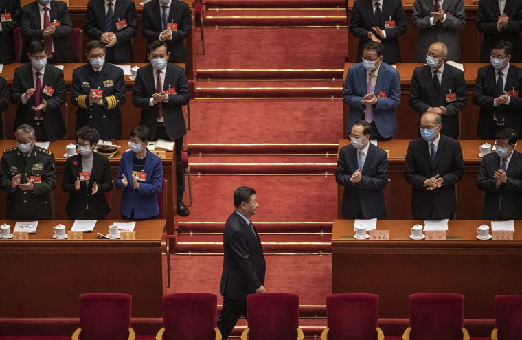 Image: Chinese President Xi Jinping, bottom, is applauded by members of the government as he arrives to the opening session of the Chinese People's Political Consultative Conference at the Great Hall of the People