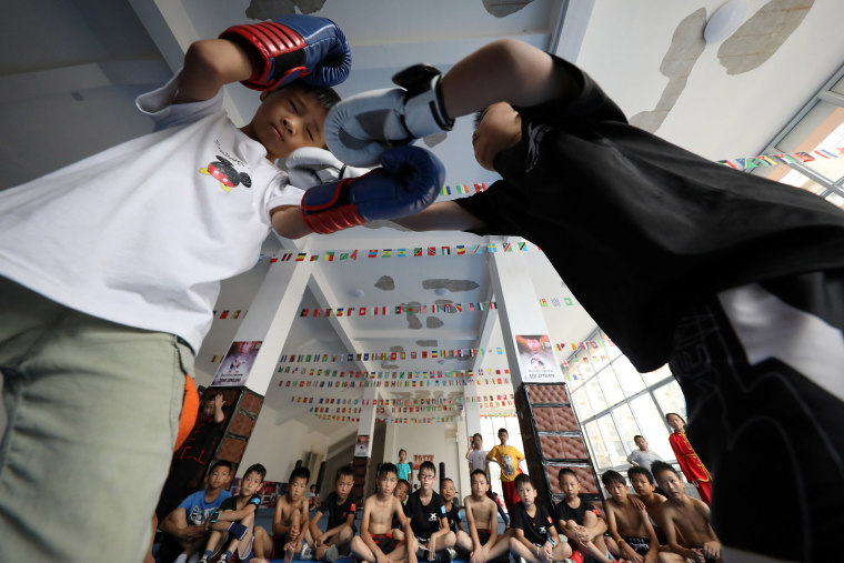 Image: Young students practice Sanda fighting skills in the gymnasium. Danzhai County, Guizhou Province, China