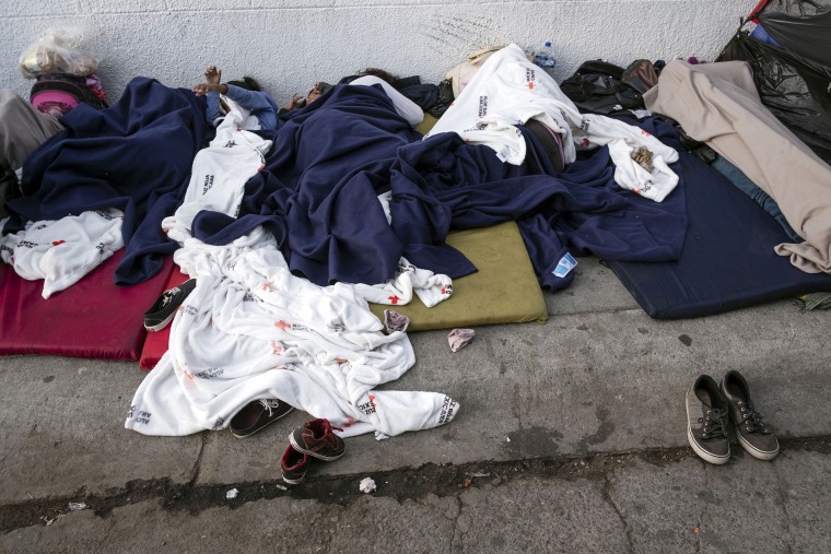 Image: Asylum seekers sleep on the street near the Paso del Norte border crossing bridge