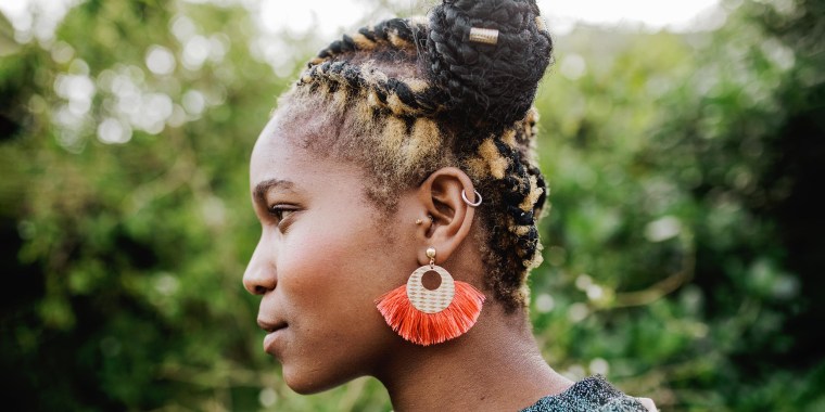 Side profile of a Woman outside, wearing a beautiful orange earring