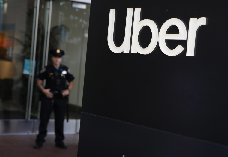 Image: A San Francisco police officer monitors a protest outside of Uber headquarters