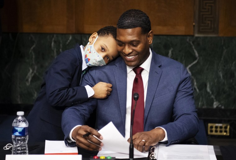 Image: Administrator of the Environmental Protection Agency nominee Michael Regan is hugged by his son, Matthew, after his confirmation hearing before the Senate Environment and Public Works committee on Feb. 3, 2021.