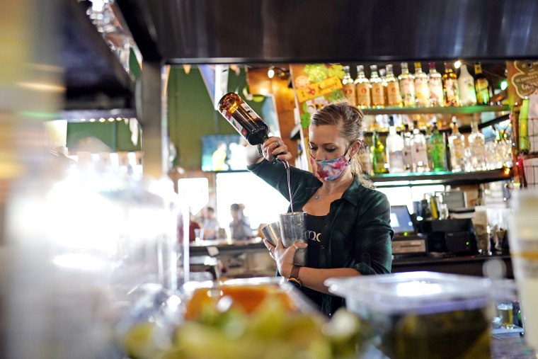 Image: A bartender makes a cocktail at a pub in Houston on March 2, 2021.