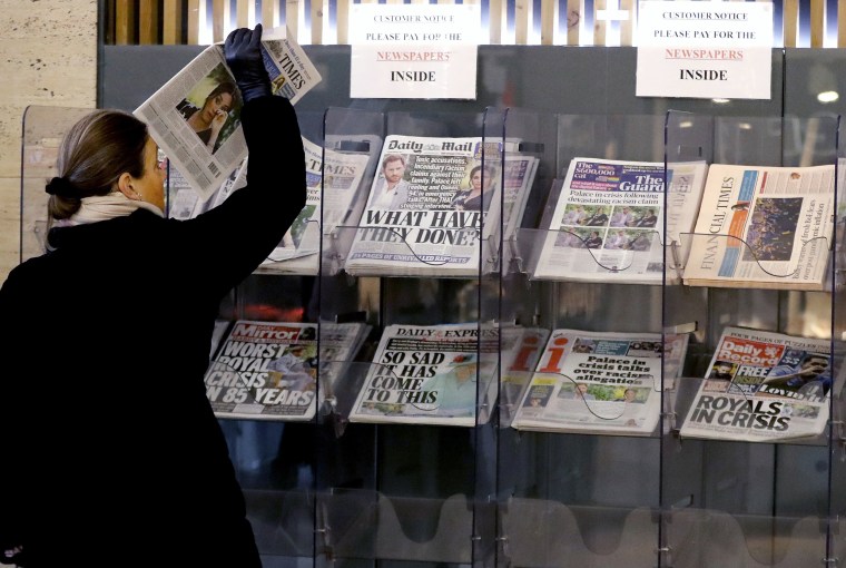 Image: A customer takes a copy of a newspaper headlining Prince Harry and Meghan's TV interview at a newspaper stand outside a shop in London