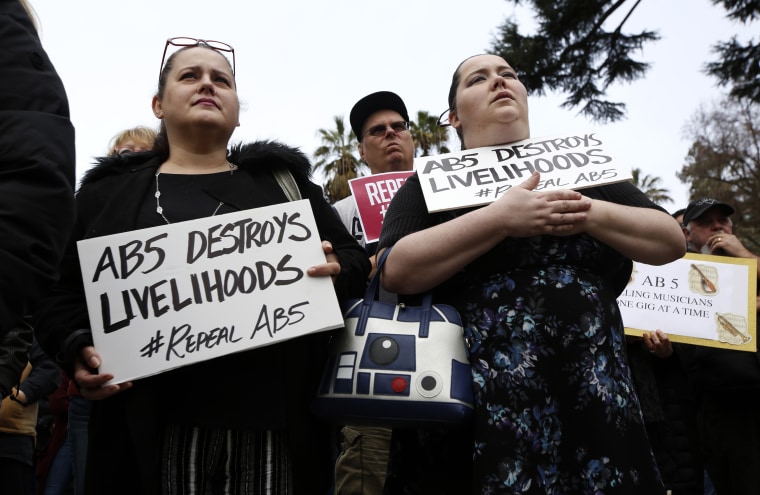 Independent contractors Jennifer Young, left, and Erika Osburn, right, rally in support of a measure to repeal a law that makes it harder for companies to label workers as independent contractors in Sacramento, Calif., on Jan. 28, 2020.