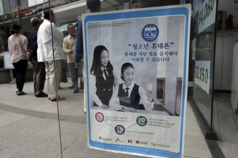 Image: A promotional banner of mobile apps that block harmful content, is posted on the door at a mobile store in Seoul, South Korea.