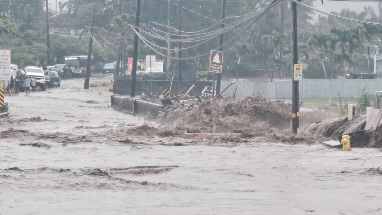 Floodwaters stream down a street in Hauula, Hawaii, on March 9, 2021.