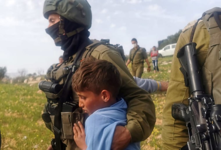 Image: Image shows Israeli soldier detaining Palestinian boy