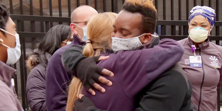 John hugs one of the staff of Long Island Jewish Forest Hills Hospital a year after he recovered from COVID-19.