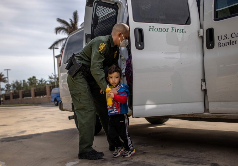 Image: A Border Patrol agent delivers a young asylum seeker and his family to a bus station in Brownsville, Texas, on Feb. 26, 2021.
